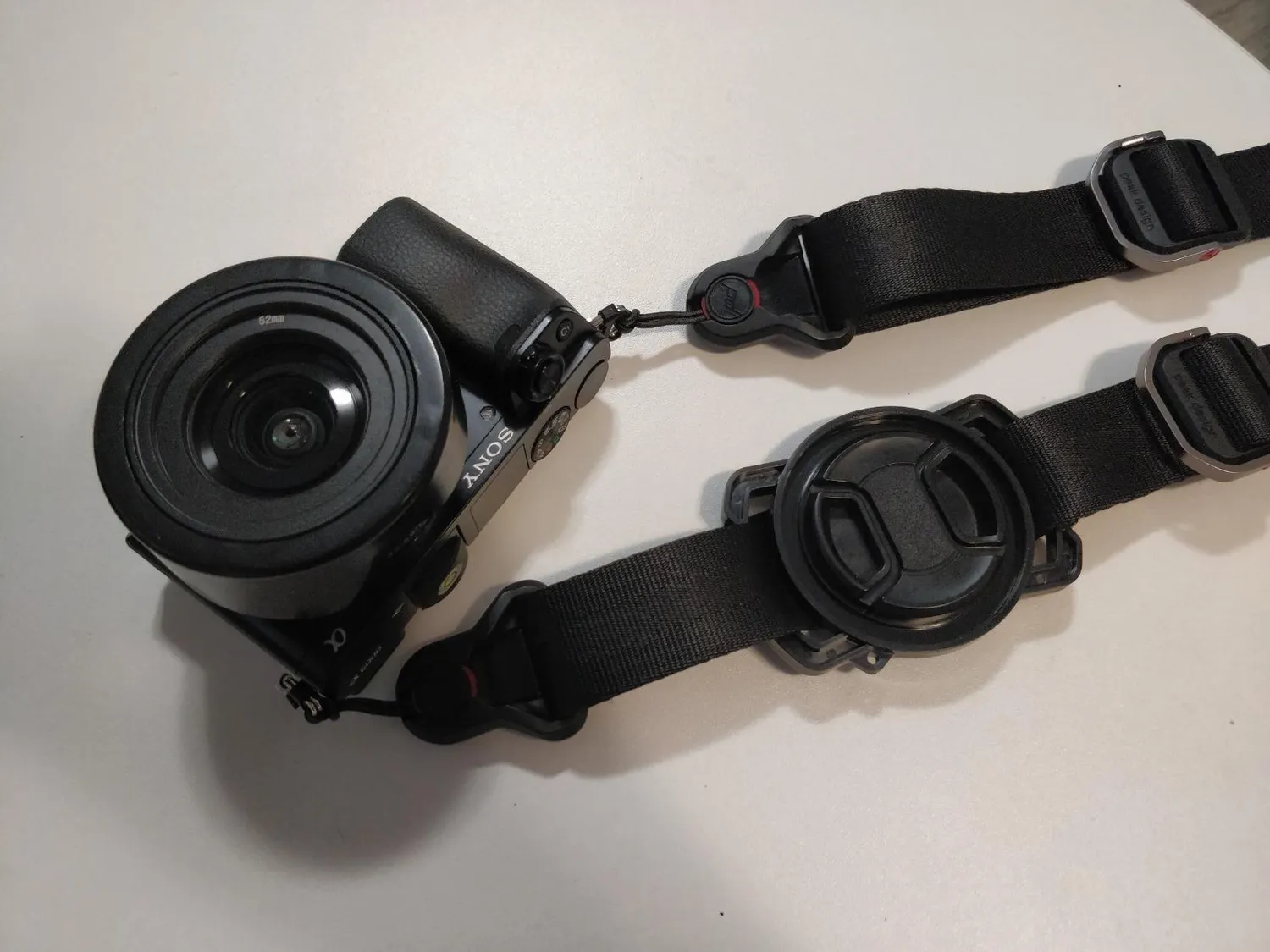 MegaGear Buckle supporto copriobiettivo 52/58/67mm tracolla